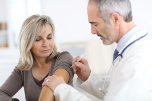 Doctor injecting flu vaccine to a woman