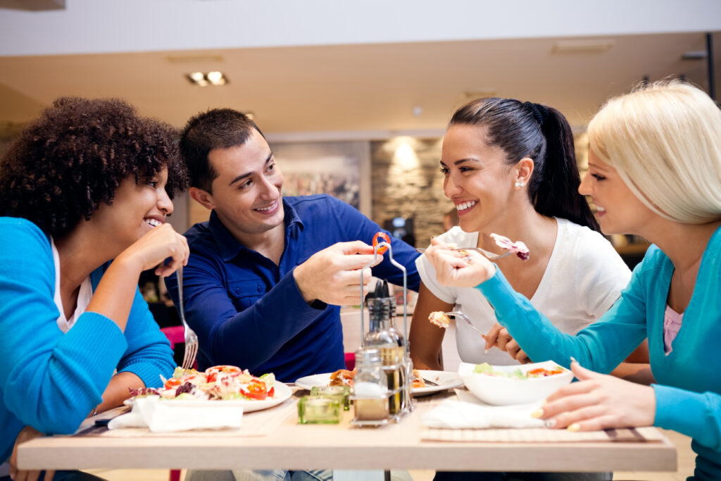 a group of people sitting around a table eating food