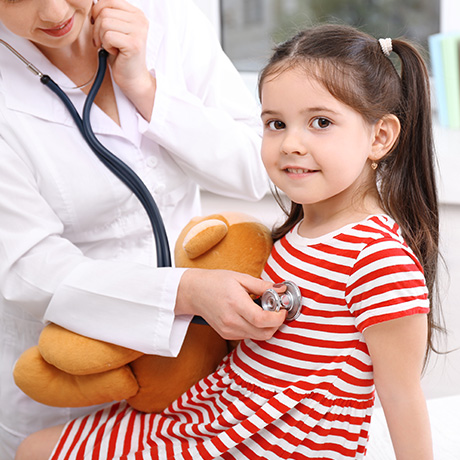 a little girl is being examined by a doctor
