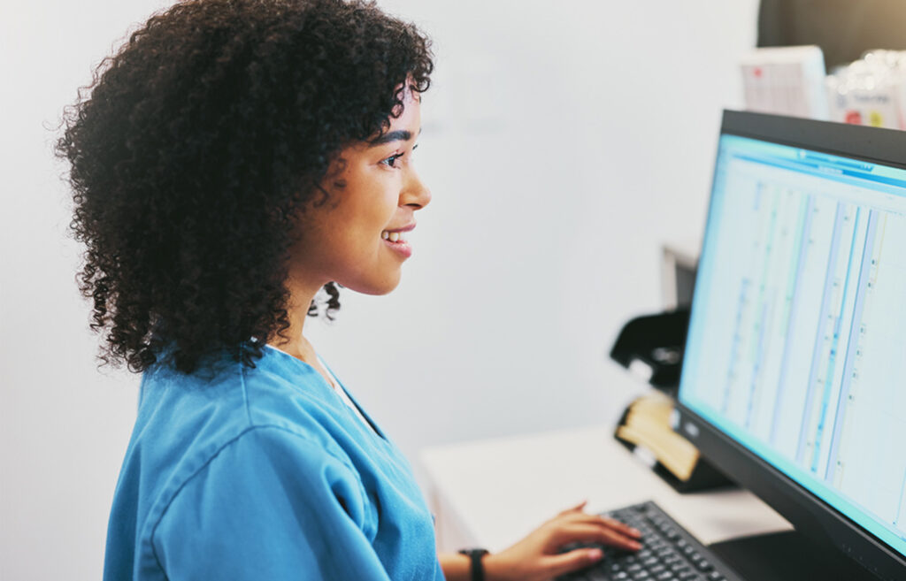 a woman sitting in front of a computer monitor