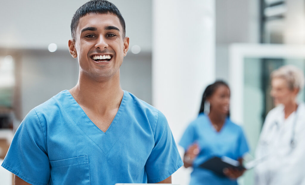 a man in scrubs is smiling at the camera