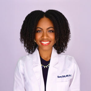 a woman in a white lab coat smiling