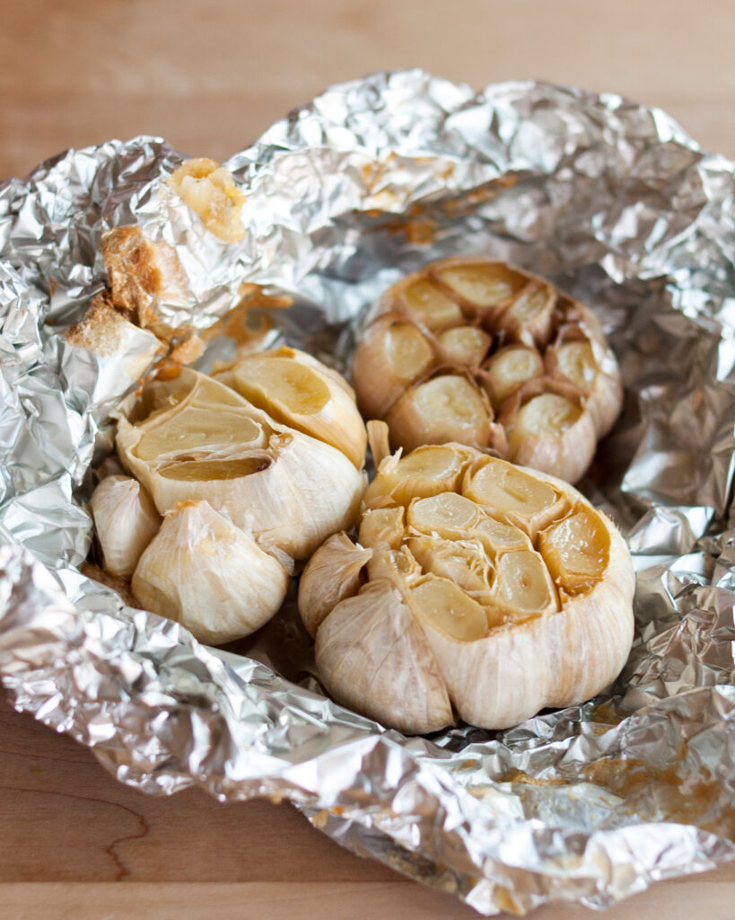 peeled garlic on aluminum foil in a bowl