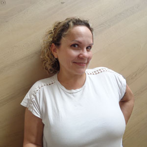 a woman standing in front of a wooden wall