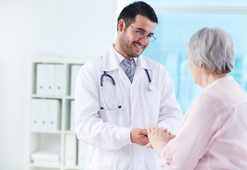 a doctor shaking hands with an elderly woman